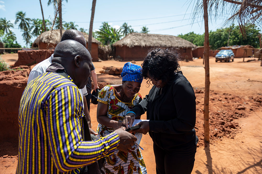 Dr. Nina Capo-Chichi berät sich mit der Familie eines Patienten in einem abgelegenen Dorf in Togo