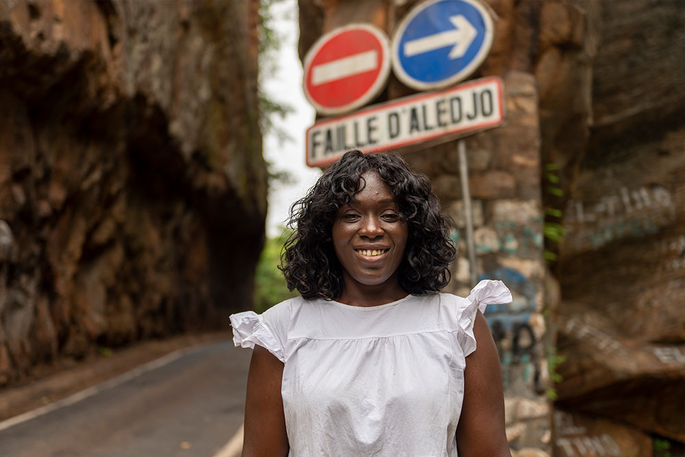 Dr. Nina Capo-Chichi lächelnd vor der Faille D'Aledjo in Togo