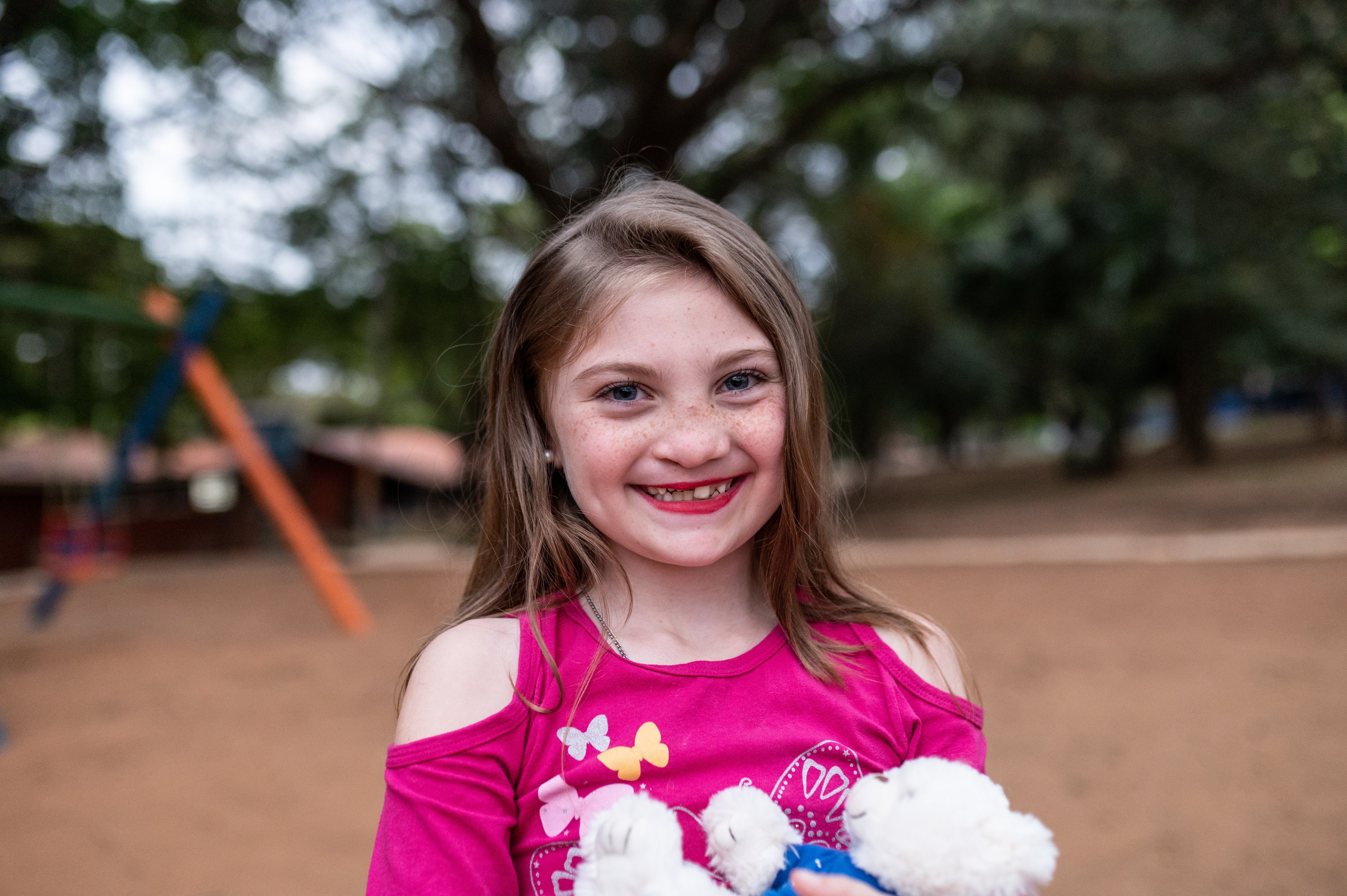 Milena lächelnd auf dem Spielplatz