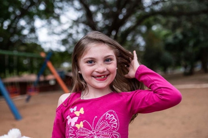 Milena lächelnd auf dem Spielplatz